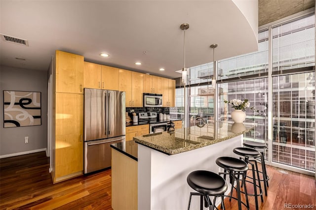 1700 Bassett St Unit 2117, Denver, CO 80202 - kitchen with appliances with stainless steel finishes, dark wood finished floors, plenty of natural light, light brown cabinetry, and recessed lighting