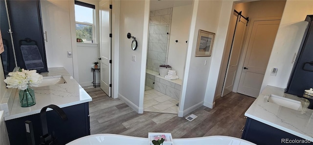 29918 Teal Run, Buena Vista, CO 81211 - full bath featuring two vanities, a freestanding bath, wood finished floors, and walk in shower