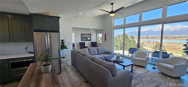 29918 Teal Run, Buena Vista, CO 81211 - living room featuring a water view, recessed lighting, a ceiling fan, wood finished floors, and baseboards