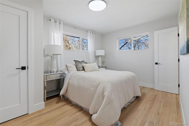 bedroom with light hardwood / wood-style flooring and multiple windows