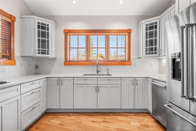 kitchen featuring a sink, light countertops, tasteful backsplash, and stainless steel appliances