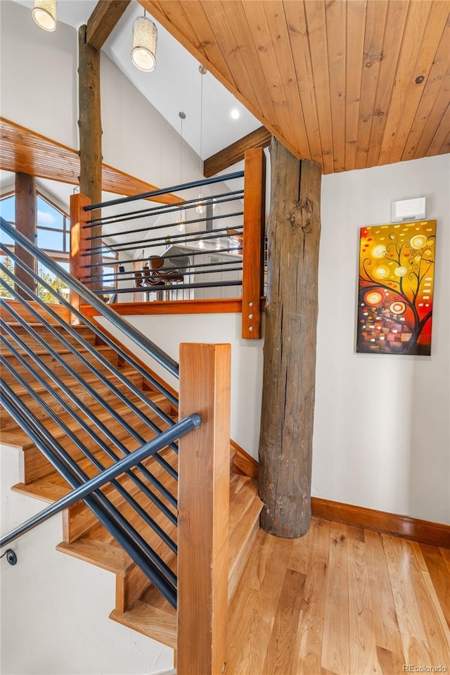 stairs featuring wooden ceiling, baseboards, lofted ceiling, and hardwood / wood-style flooring