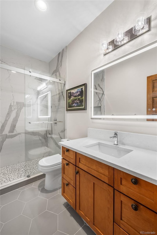 full bathroom featuring a marble finish shower, toilet, vanity, and tile patterned flooring