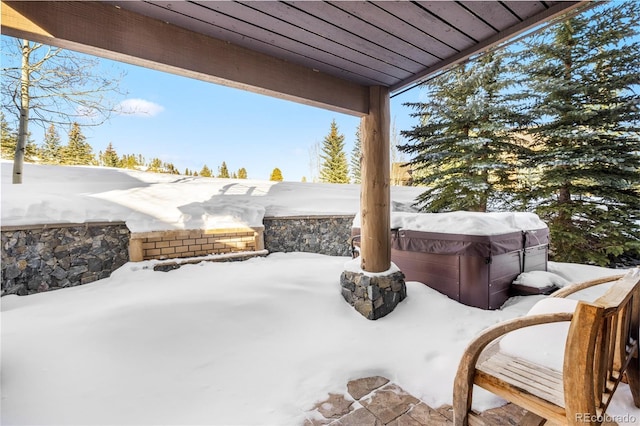 snow covered patio featuring fence and a hot tub