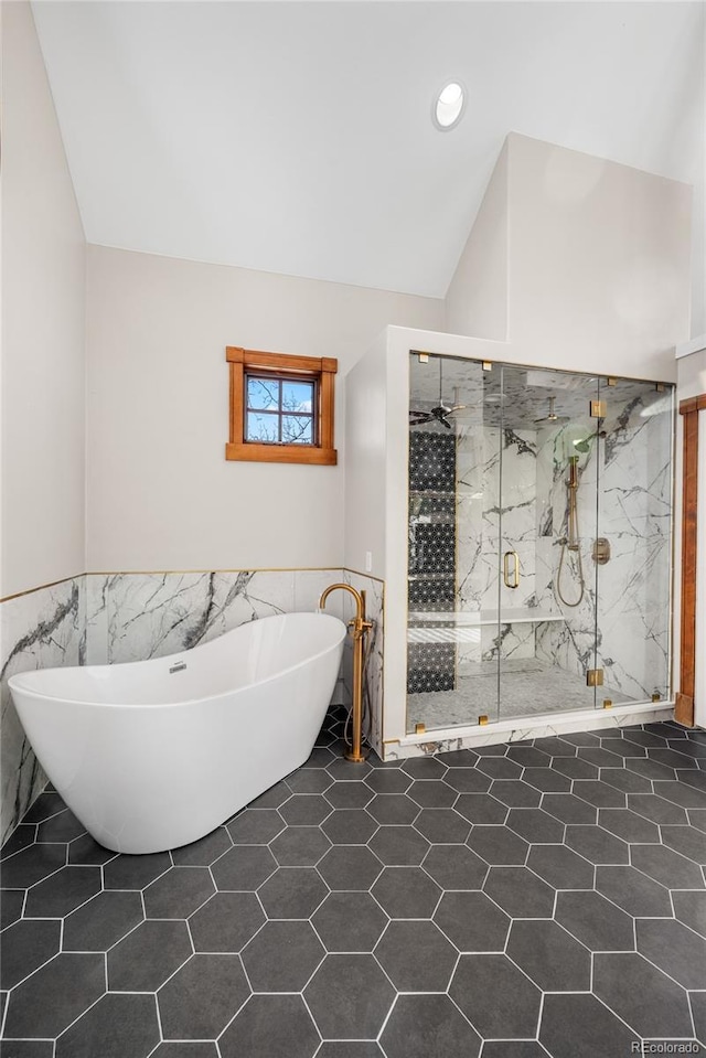 full bathroom featuring recessed lighting, a marble finish shower, tile walls, lofted ceiling, and a freestanding bath