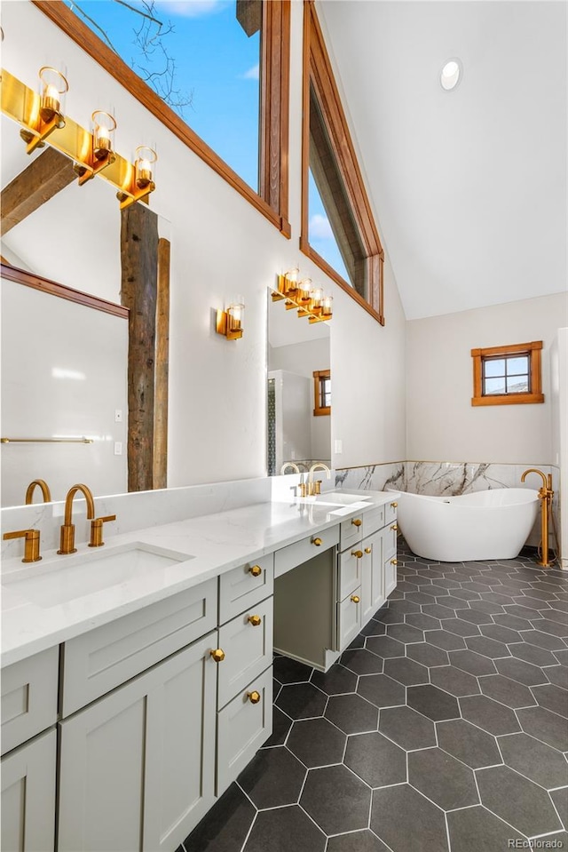 full bath with a sink, a soaking tub, double vanity, and tile patterned flooring