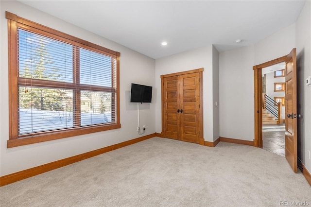 unfurnished bedroom featuring recessed lighting, baseboards, and light carpet