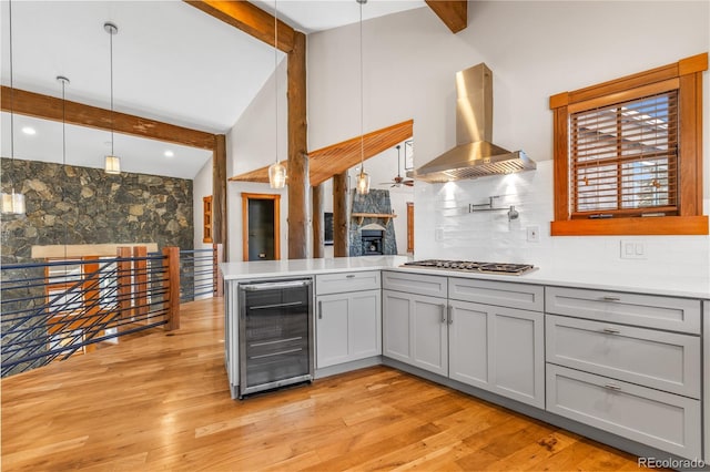 kitchen with range hood, wine cooler, gray cabinets, and stainless steel gas cooktop