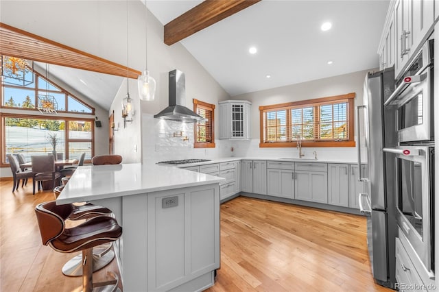 19 S Rd, Breckenridge, CO 80424 - kitchen with wall chimney range hood, a peninsula, a sink, a kitchen breakfast bar, and beamed ceiling
