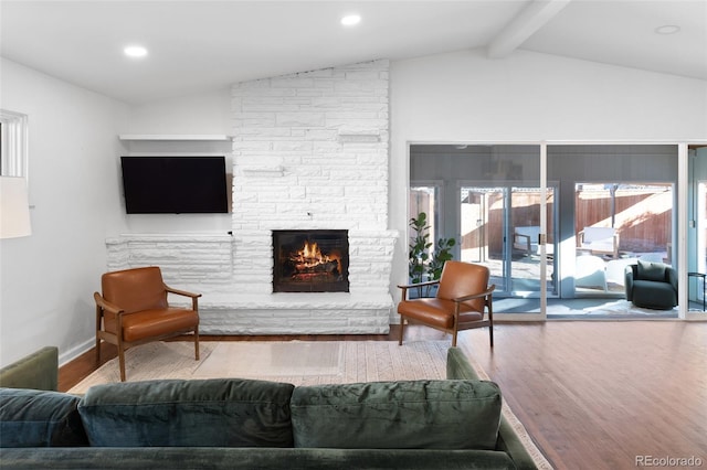 living room featuring hardwood / wood-style flooring, a fireplace, and vaulted ceiling with beams