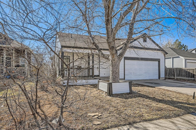 view of home's exterior with a garage, concrete driveway, and fence