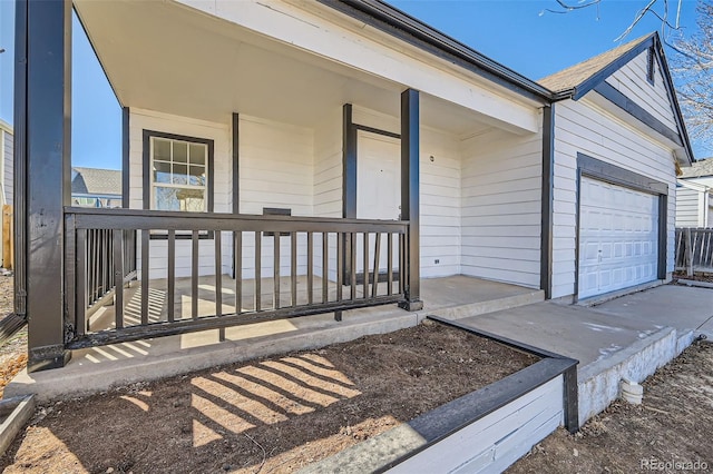 view of exterior entry with a garage and a porch