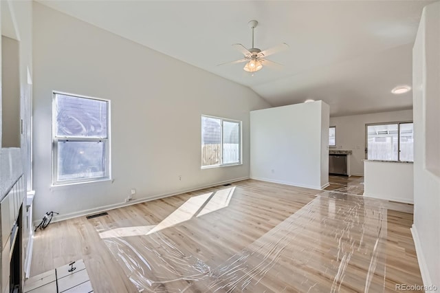 unfurnished living room with lofted ceiling, visible vents, baseboards, a ceiling fan, and light wood-style floors