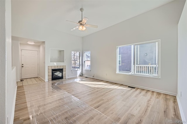 unfurnished living room with a fireplace, visible vents, light wood-style flooring, a ceiling fan, and baseboards