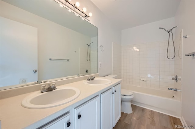 bathroom featuring  shower combination, wood finished floors, a sink, and toilet