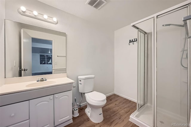 full bathroom featuring visible vents, toilet, wood finished floors, vanity, and a shower stall