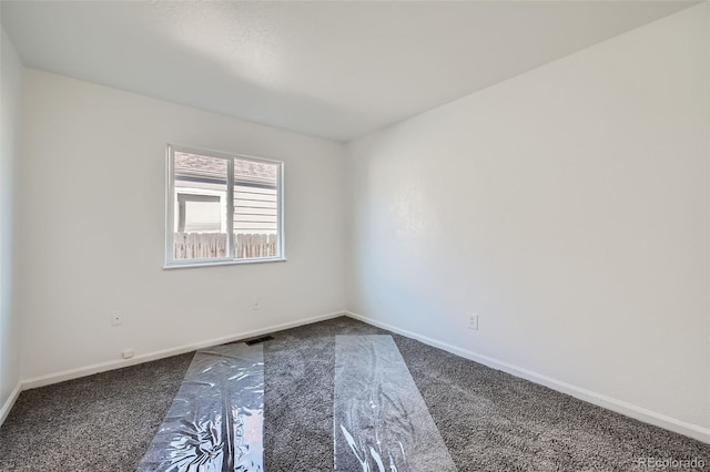 carpeted spare room with visible vents and baseboards