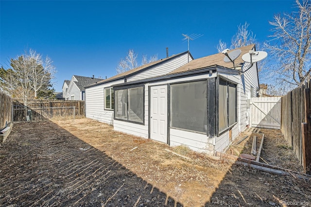 exterior space with a fenced backyard and a sunroom