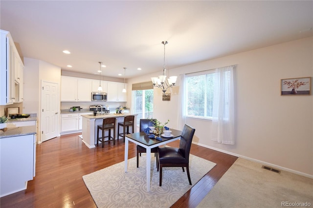 13424 W 64th Pl, Arvada, CO 80004 - dining area with dark wood finished floors, a chandelier, recessed lighting, and baseboards