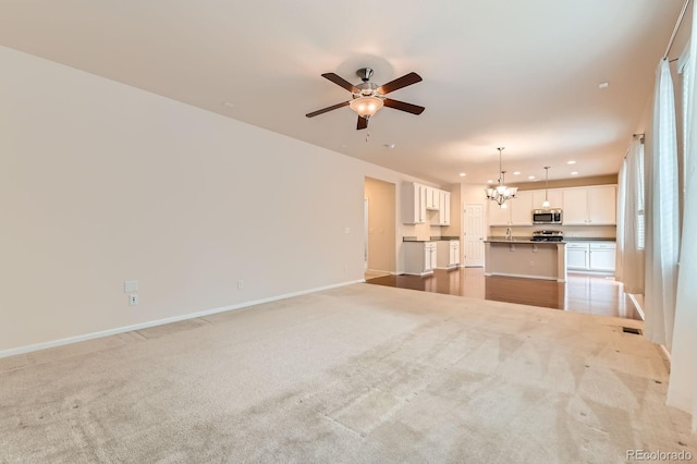 13424 W 64th Pl, Arvada, CO 80004 - unfurnished living room with a chandelier, a ceiling fan, light colored carpet, baseboards, and recessed lighting