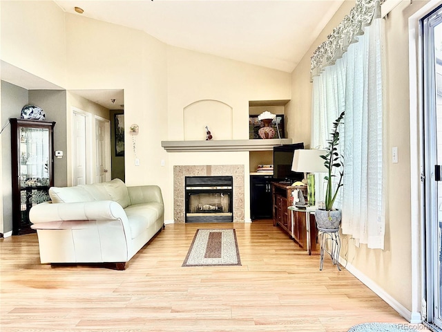 2575 S Syracuse Way Unit F301, Denver, CO 80231 - living room with lofted ceiling, light wood-type flooring, and a tile fireplace