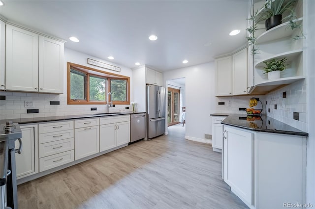 2276 S Dover Way, Lakewood, CO 80227 - kitchen with a sink, stainless steel appliances, dark countertops, open shelves, and white cabinets