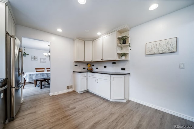 2276 S Dover Way, Lakewood, CO 80227 - kitchen with freestanding refrigerator, dark countertops, light wood-type flooring, backsplash, and recessed lighting