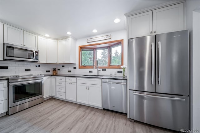 2276 S Dover Way, Lakewood, CO 80227 - kitchen with stainless steel appliances, a sink, dark countertops, backsplash, and recessed lighting