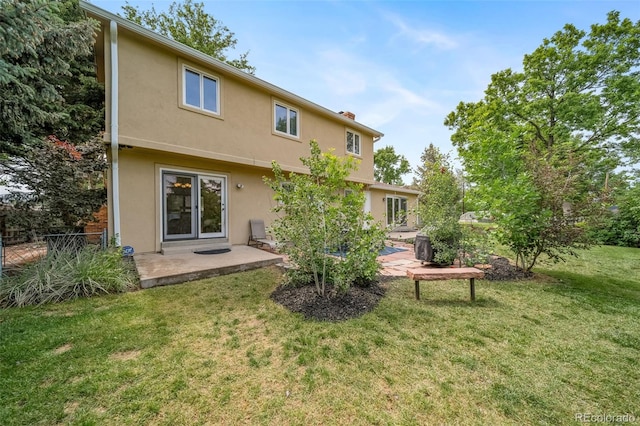 2276 S Dover Way, Lakewood, CO 80227 - back of house with stucco siding, a patio area, and a chimney