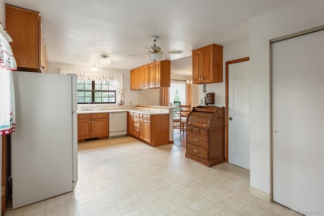 534 Crestone Ave, Salida, CO 81201 - kitchen featuring white appliances, ceiling fan, light countertops, brown cabinets, and a peninsula