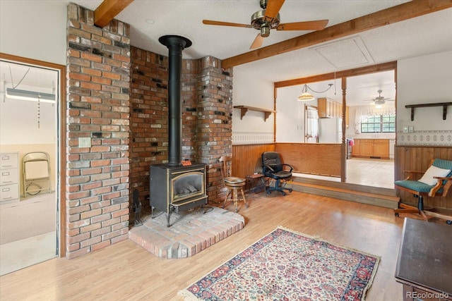 534 Crestone Ave, Salida, CO 81201 - living room with beamed ceiling, a wood stove, light wood-style flooring, ceiling fan, and wainscoting