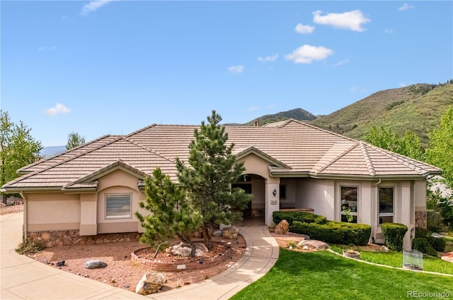 16442 Rocky Point Ln, Morrison, CO 80465 - ranch-style house with stucco siding, a tiled roof, a mountain view, and a front yard