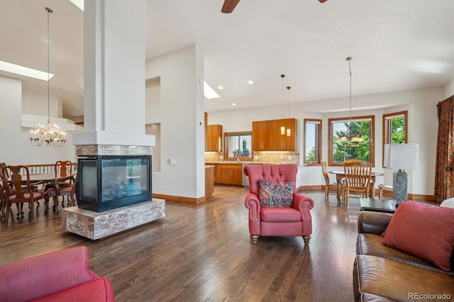 16442 Rocky Point Ln, Morrison, CO 80465 - living room with high vaulted ceiling, dark wood-style floors, a ceiling fan, and a chandelier