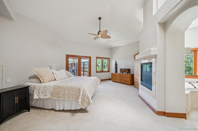 16442 Rocky Point Ln, Morrison, CO 80465 - bedroom featuring a glass covered fireplace, light colored carpet, vaulted ceiling, arched walkways, and access to outside