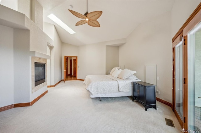 16442 Rocky Point Ln, Morrison, CO 80465 - bedroom with light carpet, a skylight, a fireplace, a ceiling fan, and high vaulted ceiling