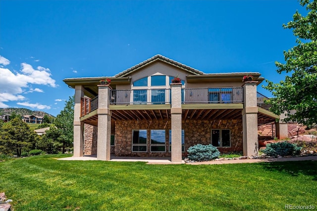 16442 Rocky Point Ln, Morrison, CO 80465 - rear view of property featuring stone siding, a balcony, a lawn, and a patio area