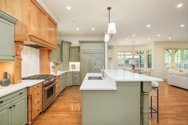 958 S Columbine St, Denver, CO 80209 - kitchen with high end range, a sink, green cabinetry, ornamental molding, and light wood-style floors