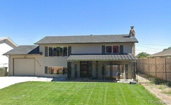 view of front of property featuring a front yard and a garage