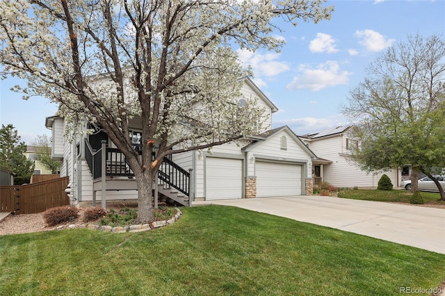 view of property hidden behind natural elements featuring a garage, stairway, fence, a front lawn, and driveway