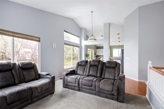 living area featuring baseboards, carpet, and vaulted ceiling