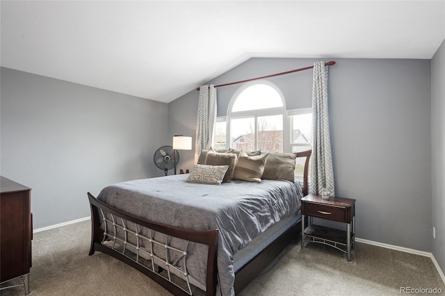 carpeted bedroom featuring baseboards and lofted ceiling