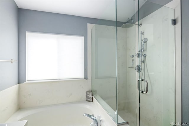 full bathroom featuring a bath and a marble finish shower