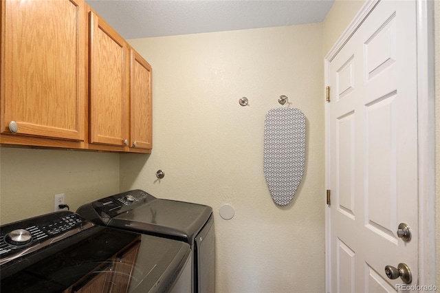 washroom featuring washing machine and dryer and cabinet space