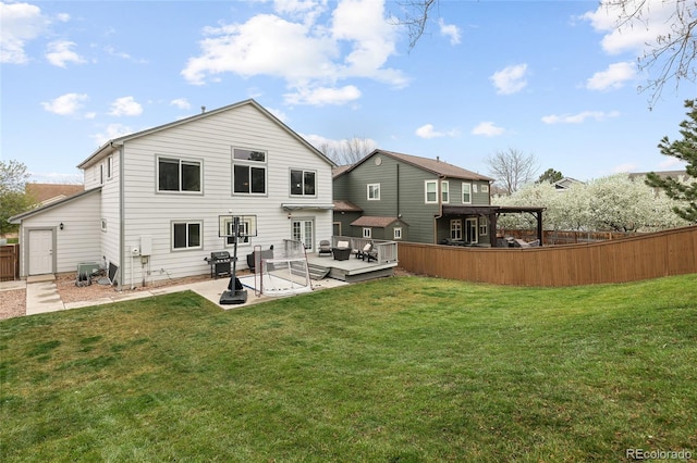 rear view of house with a yard, a patio, fence, and a deck