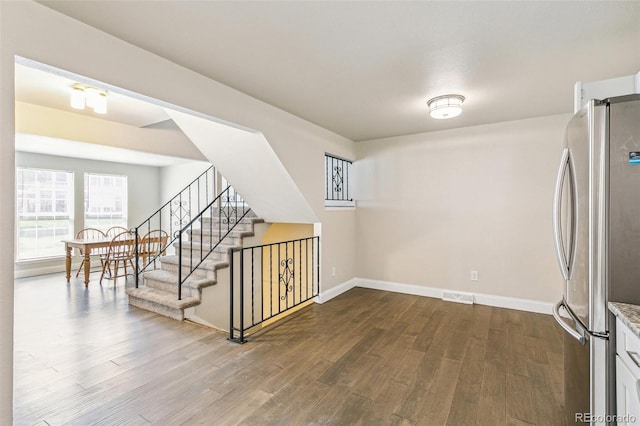 12020 E Canal Dr, Aurora, CO 80011 - unfurnished room with dark wood-style floors, baseboards, and stairway