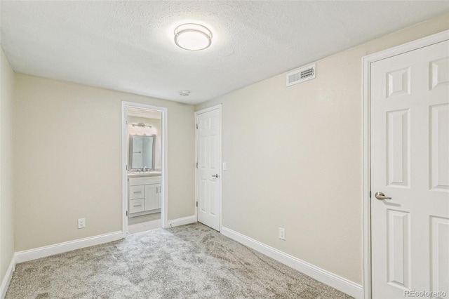 12020 E Canal Dr, Aurora, CO 80011 - unfurnished bedroom featuring carpet floors, a textured ceiling, a sink, baseboards, and ensuite bath
