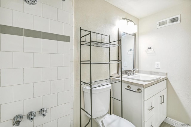 12020 E Canal Dr, Aurora, CO 80011 - bathroom with tiled shower, vanity, toilet, and a textured wall