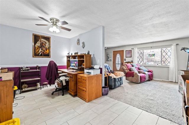 office area featuring light colored carpet, ceiling fan, and a textured ceiling