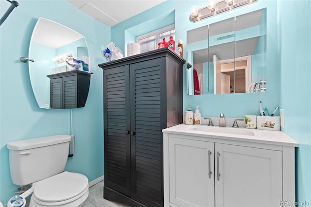 bathroom with toilet, baseboards, and vanity