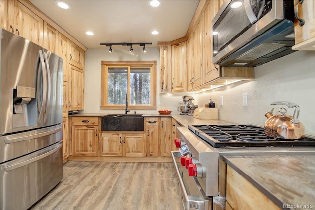 kitchen featuring sink, stainless steel appliances, light brown cabinets, and light wood-type flooring